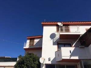 a white building with a red roof at Affittacamere Dolci Notti in Budoni
