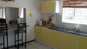 a kitchen with yellow cabinets and a sink and a window at morewag farm in Springbok