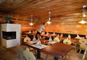 a man is standing at a table in a restaurant at Hotel Sachsenklemme in Fortezza