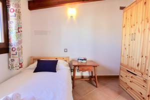 a small bedroom with a bed and a table at Eu Forat in Pollença