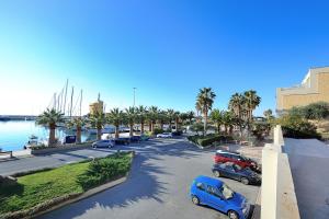 een straat met auto's geparkeerd op een parkeerplaats naast het water bij Silvia degli Aregai in Santo Stefano al Mare