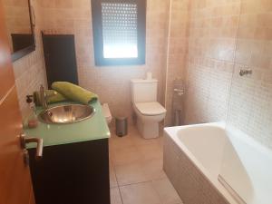 a bathroom with a sink and a tub and a toilet at El Rincon De Los Abuelos in Tudela de Duero