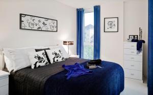 um quarto com uma cama grande e um cobertor azul em Kenavon Drive em Reading
