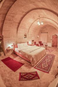 a bedroom with a large bed in a stone room at Mosaic Cave Hotel in Goreme