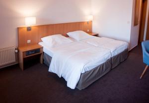 a hotel room with a large bed and a night stand at Angler Hof in Süderbrarup