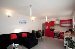 a living room with a black couch and a kitchen at Villa Grguci in Kanfanar