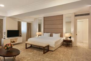 a hotel room with a bed and a television at Wyndham Tashkent in Tashkent