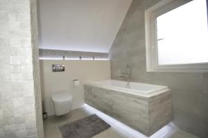 a bathroom with a sink and a toilet and a window at Domek na Plażowej Lubiatowo in Lubiatowo