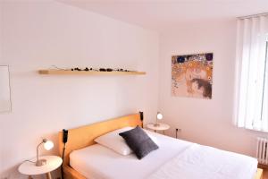 a bedroom with a white bed and two tables at Apartment D&D Spessart in Ettlingen