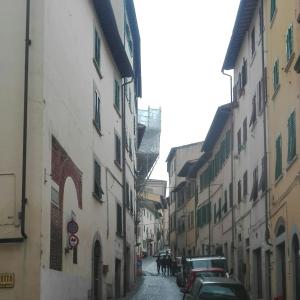 eine Gasse mit Autos auf einer Straße zwischen Gebäuden in der Unterkunft "Via Cavour 81" in Arezzo