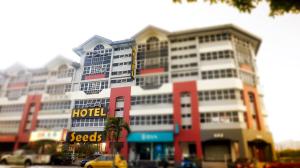 a large hotel building with cars parked in front of it at Seeds Hotel Ampang Point in Kuala Lumpur