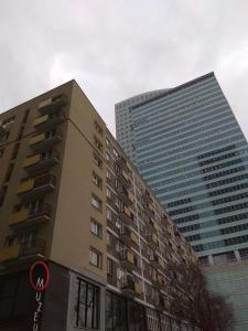 ワルシャワにあるApartament Nikolaの大きな建物前の高層ビル