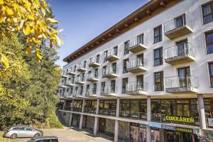 a large white building with cars parked in front of it at Crocus Apartments 310, 507 in Štrbské Pleso