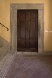 uma porta de madeira num quarto com piso em azulejo em Suite Viola Antica em Lucca