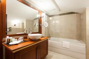 
a bathroom with a tub, sink, and shower at Ottoman Hotel Imperial-Special Category in Istanbul
