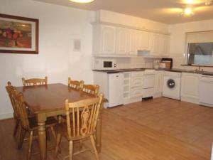 a kitchen with a table and chairs in a room at Moore Bay Holiday Homes in Kilkee