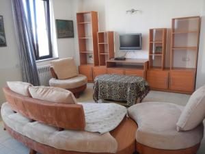 salon z 2 krzesłami i telewizorem w obiekcie Spacious apartment in Aygedzor street w Erywaniu