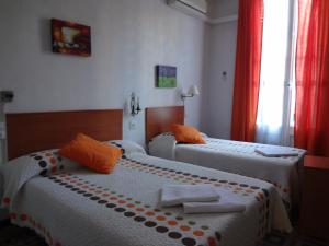 a hotel room with two beds and two lamps at Hostal Lima in Barcelona