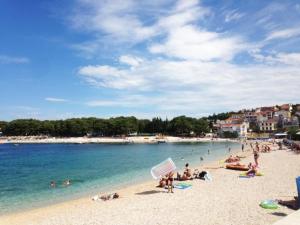 a group of people on a beach near the water at Apartman Gracin in Primošten