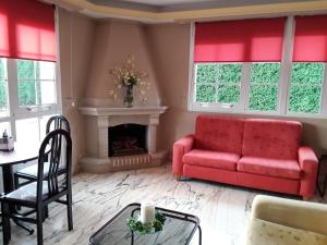 a living room with a red couch and a fireplace at Hotel Castro in Santiago de Compostela