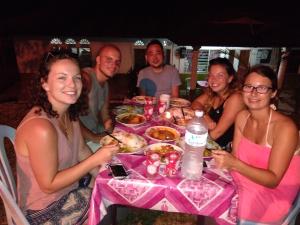 a group of people sitting at a table eating food at Delimah guesthouse in Kuala Tahan