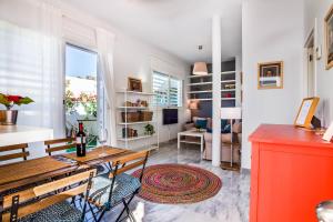 cocina y sala de estar con mesa y sillas en Encantador Ático con Terraza, en Sevilla