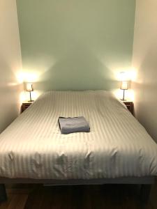 uma cama branca com uma toalha em cima em My Trip in Paris - Turgot em Paris