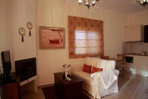 a living room with a white couch and a television at Elaion mini suites in Nafplio