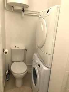 uma casa de banho com um WC e uma máquina de lavar roupa em My Trip in Paris - Turgot em Paris
