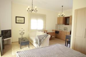 a living room with a white couch and a kitchen at Elaion mini suites in Nafplio