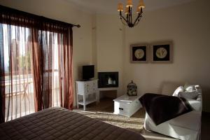 a bedroom with a bed and a tv and a window at Elaion mini suites in Nafplio