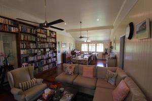 ein Wohnzimmer mit einem Sofa und Bücherregalen in der Unterkunft Gridley Homestead B&B in Eumundi