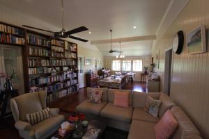 a living room with a couch and bookshelves at Gridley Homestead B&B in Eumundi