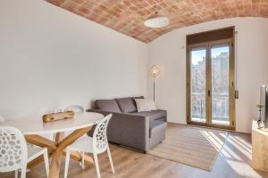 een woonkamer met een bank en een tafel en stoelen bij Flateli Girona City Center 2 in Girona