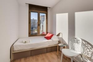 ジローナにあるFlateli Girona City Center 2のベッドルーム1室(窓、ベッド1台、椅子付)