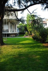 a house with a yard with green grass and a tree at La Villa Del Cedro in Monza