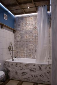 a bathroom with a bath tub with a shower curtain at Rassl Country Home in Rostov on Don