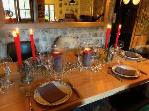 a table with candles and plates and glasses on it at La Cour Sainte Catherine demeure de charme in Honfleur