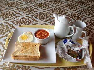 阿克拉的住宿－Benconi Lodge，包括鸡蛋、面包和豆子的早餐盘