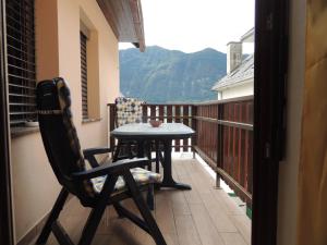 a table and a chair on a balcony with a view at Apartma Bovec in Bovec