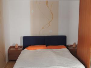 a bed with two orange pillows in a bedroom at Apartma Bovec in Bovec