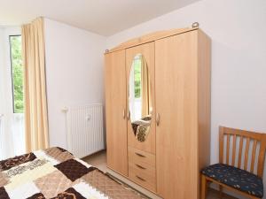 a bedroom with a wooden cabinet with a mirror at Ferienwohnung-8-3 in Baabe
