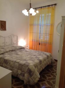 ヴェルナッツァにあるAppartamento Andromedaのベッドルーム1室(ベッド1台、ランプ、窓付)