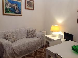 un soggiorno con divano e tavolo con lampada di Appartamento Andromeda a Vernazza