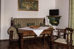 a table and chair with a bowl on top of it at Jagdschloss Fahrenbühl Hotel Garni in Kirchenlamitz