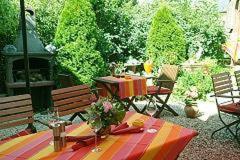 eine Terrasse mit einem Tisch, 2 Bänken und einem Tisch in der Unterkunft Hotel Vinum in Niederwurschnitz