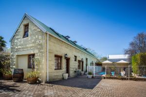 an old stone house with a brick courtyard at 88 Baron van Reede Guesthouse in Oudtshoorn