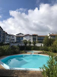 ein großer blauer Pool vor einigen Gebäuden in der Unterkunft Ibaia Sokoburu dream in Hendaye