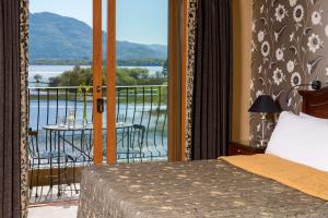 a hotel room with a balcony overlooking the ocean at The Lake Hotel in Killarney