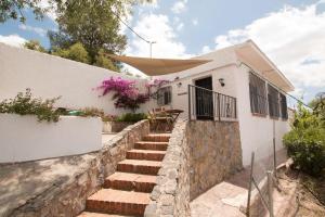 a white house with stairs leading up to it at Finca Bella Vista in Alhaurín el Grande